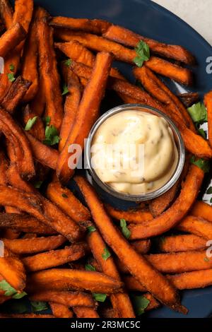 Köstliche Süßkartoffeln-Pommes, serviert mit Sauce, Nahaufnahme Stockfoto