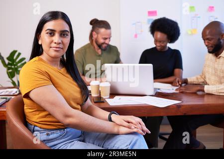Ernsthaftes Porträt einer Indianerin während einer kreativen Teambesprechung am Sitzungstisch Stockfoto
