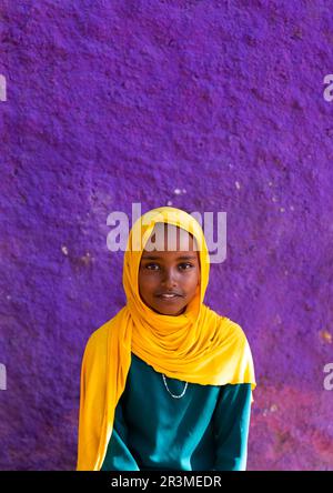 Süßes äthiopisches Mädchen vor einer lila Mauer, Harari Region, Harar, Äthiopien Stockfoto