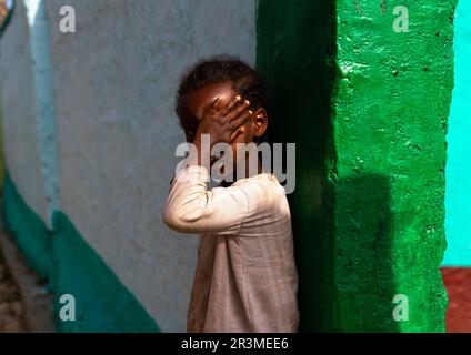 Äthiopisches Mädchen, das ihr Gesicht auf der Straße versteckt, Harari Region, Harar, Äthiopien Stockfoto