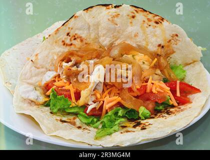 Fisch mit Zwiebeln und Salat in einer Tortilla. Stockfoto