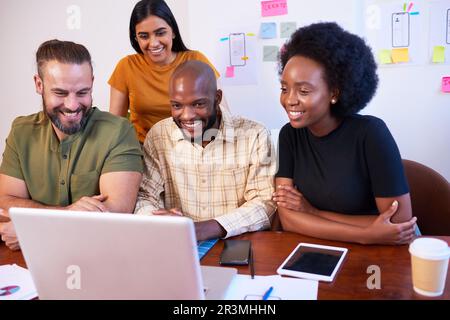 Vier junge Mitglieder des Tech-Startups nehmen an Videogesprächen, Gruppenbesprechungen und lächelnden Gesprächen Teil Stockfoto