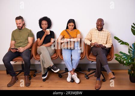 Vier Kandidaten sitzen hintereinander und warten auf ein Vorstellungsgespräch, kreativer Tech-Programmierer Stockfoto