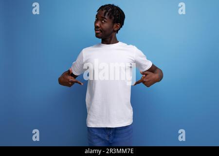 Eleganter junger Mann mit Dreadlocks in einem weißen T-Shirt mit leerem Platz für Logo Stockfoto