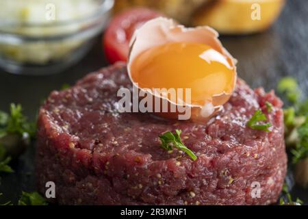 Steak Tartare auf schwarzem Schiefer Stockfoto