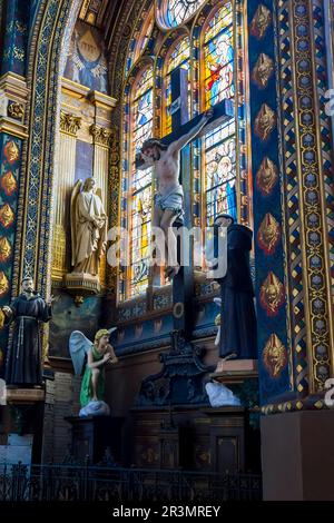 Dies ist eine der Ecken der Kirche Saint-Eustache mit einem Kruzifix, Figuren von Engeln und Mönchen an den Buntglasfenstern vom 13. Mai 2013 in Paris. Stockfoto