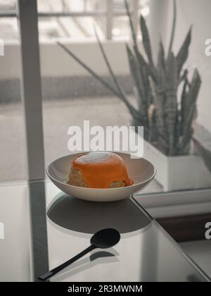 Köstlicher hausgemachter Haferlavenkuchen mit weißem Sesam in weißer Keramikplatte serviert mit Löffel auf dem Tisch. Delicious Bakery Concept, Platz für Text, SE Stockfoto