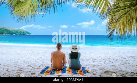 Tropischer weißer Strand auf Praslin Island Seychellen, glückliches junges Paar Mann und Frau am Strand Stockfoto