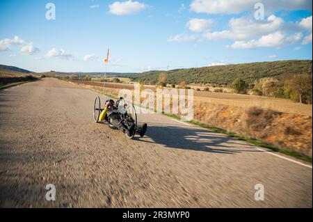 Sportler mit Behinderungstraining mit seinem Handbike auf der Rennstrecke. Stockfoto