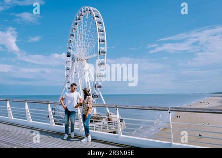 Paare besuchen das Riesenrad The Pier in Scheveningen, Den Haag, Niederlande Stockfoto