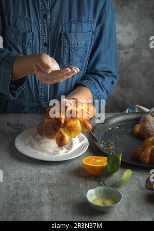 Frau, die Pan de muertos Brot der Toten für den mexikanischen Tag der Toten bereitet Stockfoto