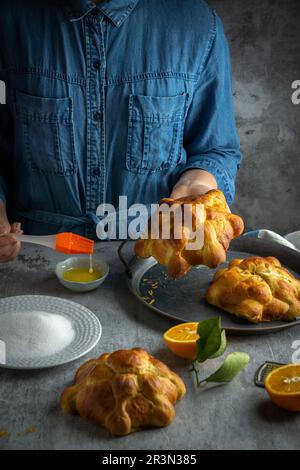 Frau, die Pan de muertos Brot der Toten für den mexikanischen Tag der Toten bereitet Stockfoto