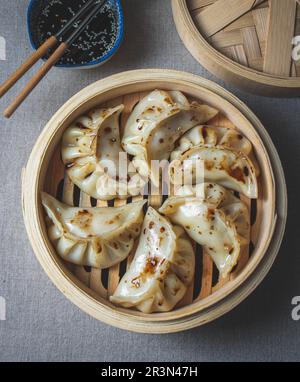 Gyoza japanische koreanische Knödel auf grauem Teller auf dem Tisch. Draufsicht Stockfoto