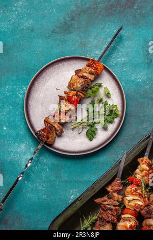 Gegrilltes Schweinefleisch und Gemüsespieße auf grauem Teller. Draufsicht, flach liegend Stockfoto