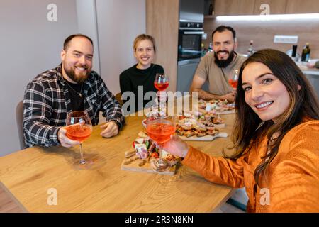 Eine Gruppe von Freunden, die zu Hause einen Brunch genießen und sich amüsieren Stockfoto