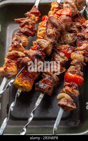 Gegrilltes Schweinefleisch, Huhn und Gemüsespieße auf dem Tablett. Draufsicht, flach liegend Stockfoto