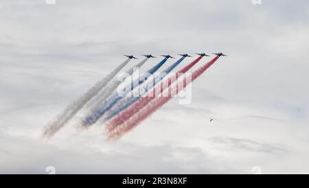 31. Juli 2022, St. Petersburg, Russland. Sukhoi Su-25 greift Flugzeuge an, die bei der Main Naval Parade in Rauch in den Farben der russischen Flagge abgegeben haben Stockfoto