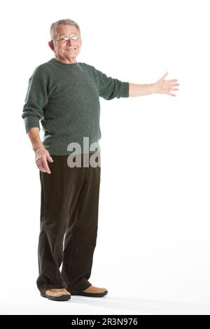 Senioren: Präsentation. Ein freundlicher Seniorenmensch, der den Raum neben ihm kopieren will. Porträt über die gesamte Länge, isoliert auf Weiß. Aus einer Serie. Stockfoto