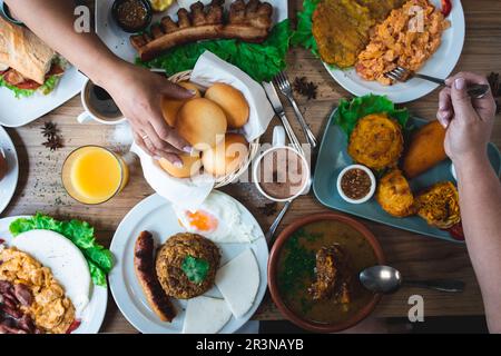 Blick von oben auf unbekannte Weibchen, die bei Tageslicht im Restaurant köstliche lateinamerikanische Gerichte essen Stockfoto