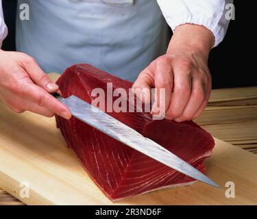 Thunfisch wird für Sushi geschnitten Thunfischfilet wird chirurgisch präzise geschnitten Stockfoto