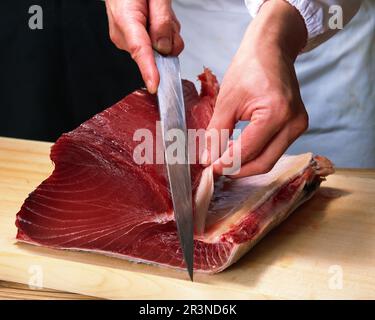 Thunfisch wird für Sushi geschnitten Thunfischfilet wird chirurgisch präzise geschnitten Stockfoto