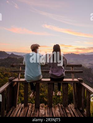 Ein paar Männer und Frauen beobachteten den Sonnenaufgang, Morgennebel Aussichtspunkt Phu Pha Mok Baan Jabo Stockfoto