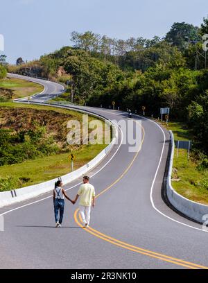 Ein Paar, das auf einer kurvenreichen Straße in den Bergen von Nan Thailand spaziert, Straße Nr. 3 Landstraße Stockfoto
