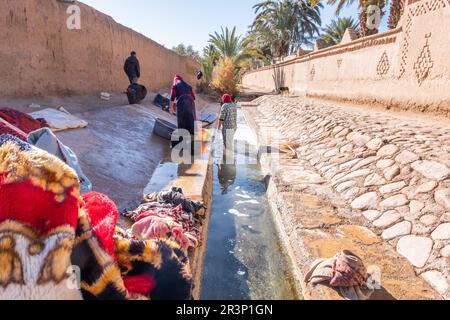 Frauen waschen ihre Kleidung in dem Bewässerungssystem, das von den Gipfeln des Hohen Atlas kommt Stockfoto