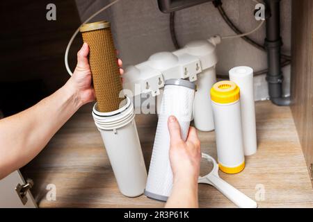 Der Installateur installiert oder wechselt den Wasserfilter. Ersatz-Aqua-Filter Stockfoto