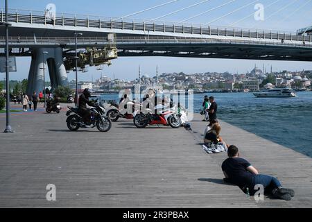 Istanbul, Türkei - 21. Mai 2023: Eine Gruppe von Motorradfahrern am Goldenen Horn, an der Küste von Istanbul, mit der U-Bahn-Brücke im Hintergrund. Stockfoto