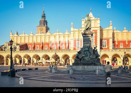 Krakau, Polen - 21. Oktober 2012: Die Statue von Adam Mickiewicz und Tuchhalle (Sukiennice) auf dem Hauptplatz in Krakau. Altstadt von Krakau (Polen) Stockfoto