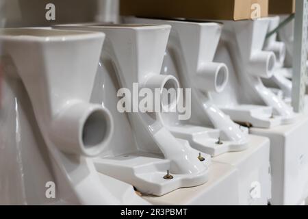 Viele weiße Toiletten im Baumarkt, in der Klempnerabteilung Stockfoto