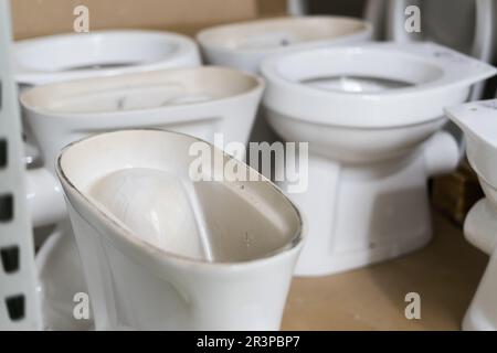 Viele weiße Toiletten im Baumarkt, in der Klempnerabteilung Stockfoto