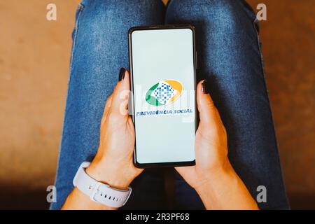 In dieser Fotoabbildung wird das Logo von Previdência Social (Instituto Nacional do Seguro Social) auf einem Smartphone-Bildschirm angezeigt. Stockfoto
