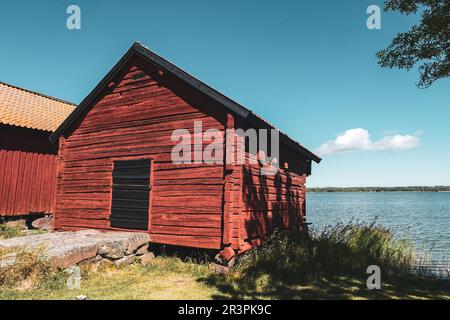 Blick auf die Scheune auf dem Feld neben dem See gegen den Himmel Stockfoto