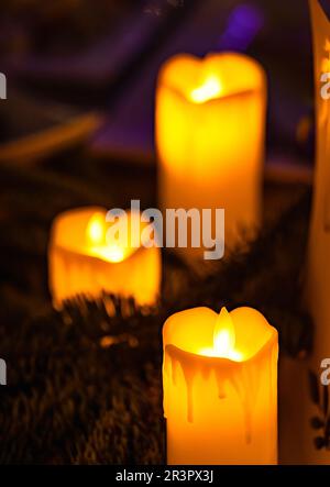 Nahaufnahme einer klassischen Kerze mit orangefarbenen Flammen Stockfoto