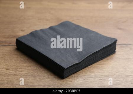 Stapel schwarzer sauberer Papiertücher auf Holztisch Stockfoto