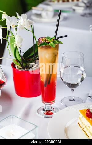 Cocktail in zweilagigem Glas mit tropischen Früchten Stockfoto