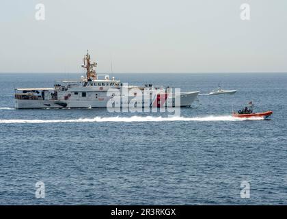 230523-N-NH267-1094 STRASSE VON HORMUZ (23. Mai 2023) USCG Cutter Clarence Sutphin Jr. (WPC 1147) durchquert die Straße von Hormuz mit einem unbemannten Überwasserschiff L3 Harris Arabian Fox MAST-13 vom 23. Mai 2023, aus Sicht des Guided-Missile Destroyers USS Paul Hamilton (DDG 60). Paul Hamilton wird im US-Flottengebiet 5. eingesetzt, um die Sicherheit und Stabilität der Seeschifffahrt im Nahen Osten zu gewährleisten. (USA Marinebild von Mass Communication Specialist 2. Class Elliot Schaudt) Stockfoto