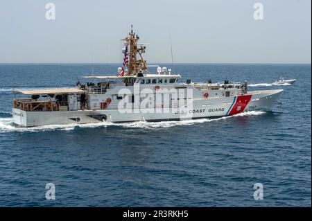 230523-N-NH267-1127 STRASSE VON HORMUZ (23. Mai 2023) USCG Cutter Clarence Sutphin Jr. (WPC 1147) durchquert die Straße von Hormuz mit einem unbemannten Überwasserschiff L3 Harris Arabian Fox MAST-13 vom 23. Mai 2023, aus Sicht des Guided-Missile Destroyers USS Paul Hamilton (DDG 60). Paul Hamilton wird im US-Flottengebiet 5. eingesetzt, um die Sicherheit und Stabilität der Seeschifffahrt im Nahen Osten zu gewährleisten. (USA Marinebild von Mass Communication Specialist 2. Class Elliot Schaudt) Stockfoto