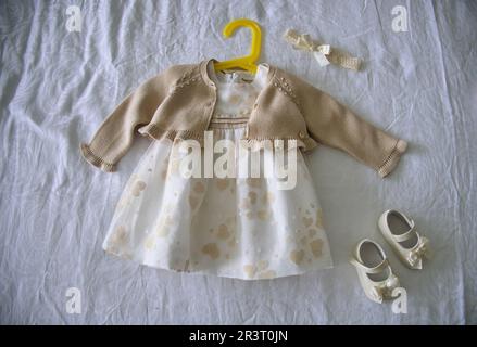 Taufe-Hintergrund mit Taufe-Babykleid und -Schuhen Stockfoto