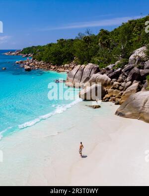 Junge Männer an einem weißen Strand mit türkisfarbenem Meer, Blick auf die Drohne von oben am Strand von Anse Lazio Praslin Island Seychellen Stockfoto