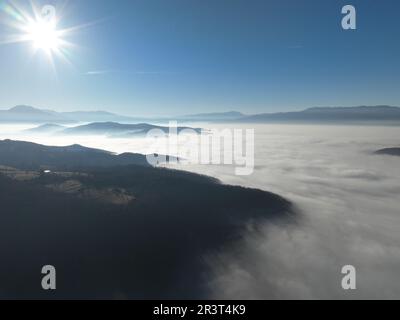 Luftaufnahme. Fliegen Sie über die hohen Berge in wunderschönen Wolken. Drohnen-Kamera aus der Luft. Luftverschmutzungswolken über Sarajevo Stockfoto