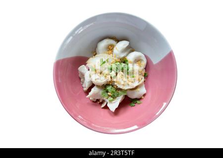 Schnitt von gekochten Fischbällchen in einer Schüssel mit frittiertem Knoblauch auf weißer, isolierter Oberfläche. Stockfoto