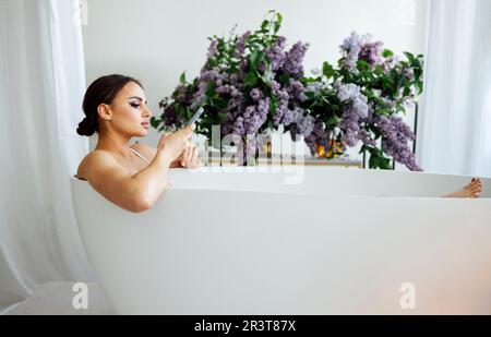 Seitliches Porträt einer hübschen Asiatin, die eine Nachricht auf dem Handy tippt Stockfoto
