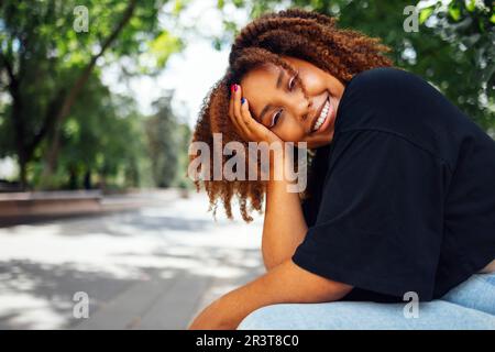 Nahaufnahme von welligem Haar charmante, fröhliche dunkle Haut Person hat gute Laune Stockfoto