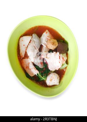 Gestanzte Yentafo Fish Ball Noodles in einer grünen Schüssel in rosafarbener Suppe auf weiß isoliert. Stockfoto