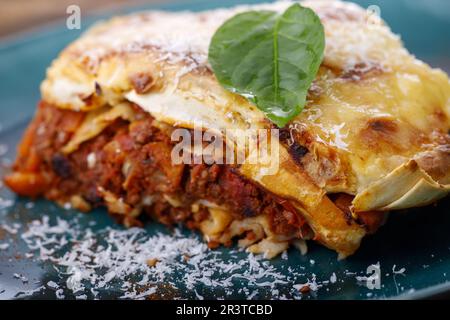 Italienische Lasagne auf blauem Teller Stockfoto