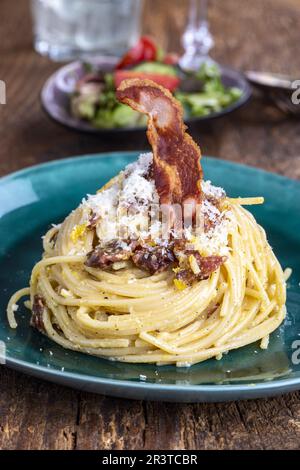 Spaghetti Carbonara mit Salat auf Holz Stockfoto