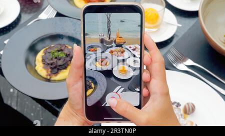 Nahaufnahme der Hände einer Frau mit dem Smartphone, um Fotos vom Abendessen zu machen Stockfoto